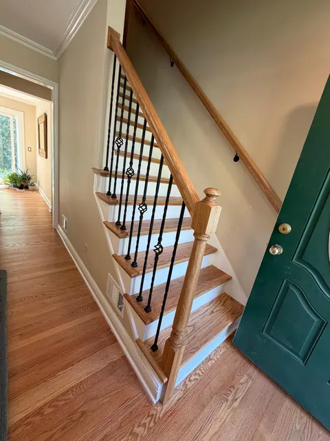 After: the same staircase with new oak treads, white risers and iron balusters