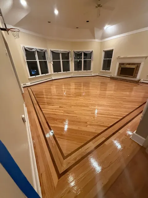 Refinished floor with a dark inlay border in a bay-window room