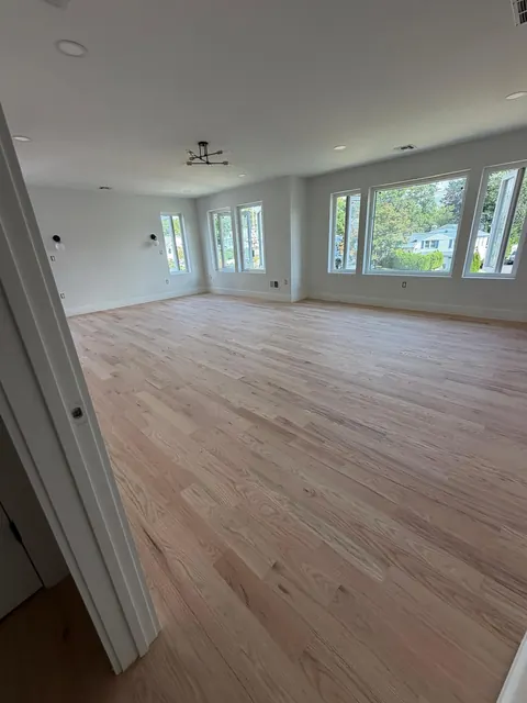 Freshly sanded raw oak floor in an open living room, ready for finish