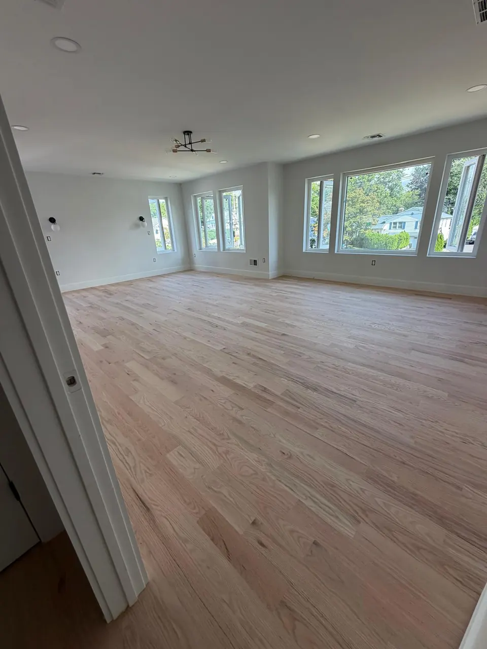 Open living room with oak floor sanded to raw wood, ready for finish